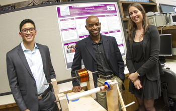 Students standing around an engineering device